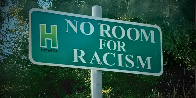 Green street Sign that reads, "No Room for Racism"