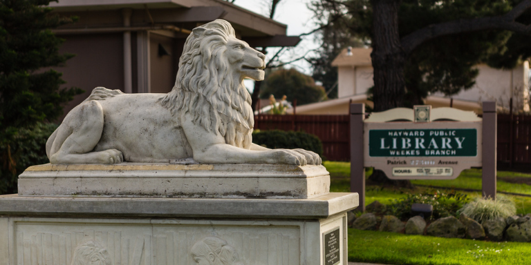 Photo of the lion statue in front of the main entrance of the Weekes Library.