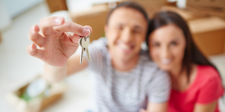 A couple smiling holding house keys