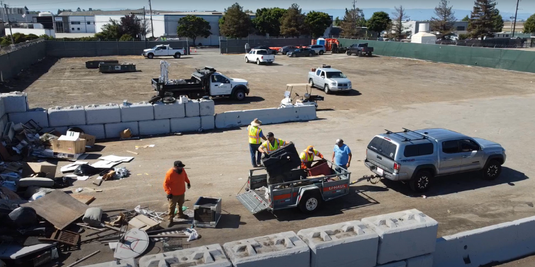 Staff members unloading debris during a part disposal days activity