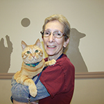 Tina Burke in a red shirt holding an orange cat