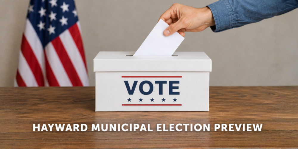A person wearing a blue shirt putting a ballot into a white "Vote" box in front of the American flag. Below is the text: Hayward Municipal Election Preview