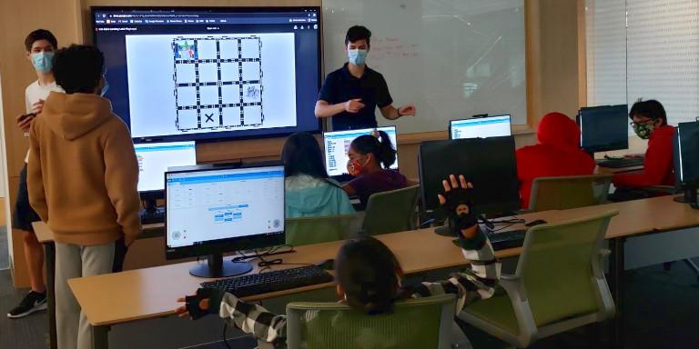 A teacher presents a coding program to children