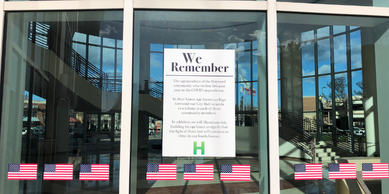 A row of American Flags underneath a "We Remember"  Poster