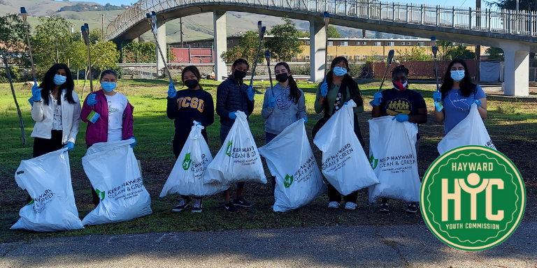Photo of Hayward Youth Commissioners picking up trash outdoors.