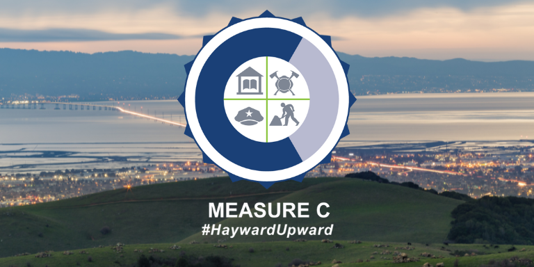 Photo of a view from the City of Hayward from the hills with a blue and white Measure C logo on top.