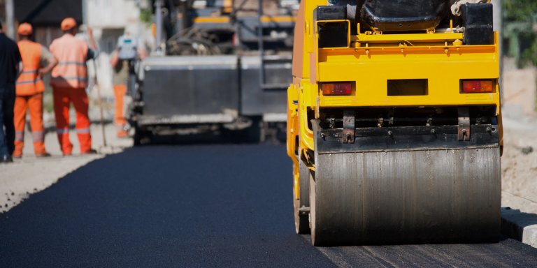 A group of workers paving a road