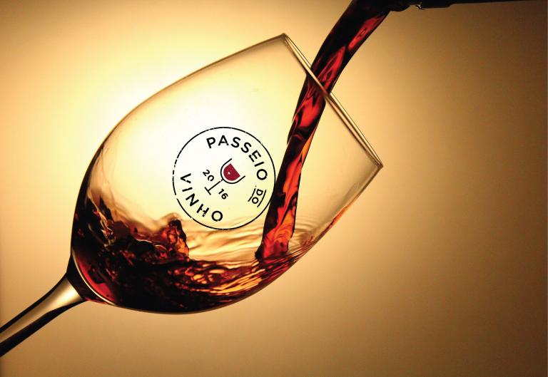 Red wine being poured into a glass with the Passeio do Vinho label