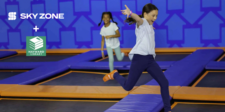 Photo of two kids bouncing on trampolines. To the left the SkyZone and the Hayward Public Library logos.