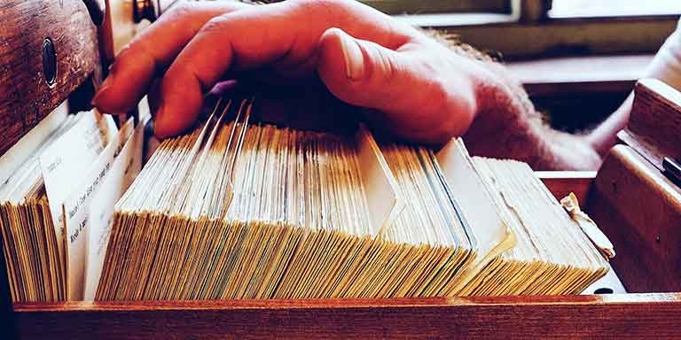 A person shuffling through a card catalog